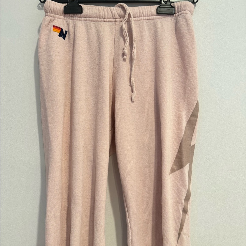Aviator Nation pale pink sweatpants with faded gold lightening bolt